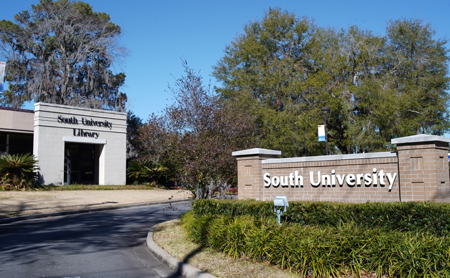 south university campus entrance with brick sign on the right and the library building on the left