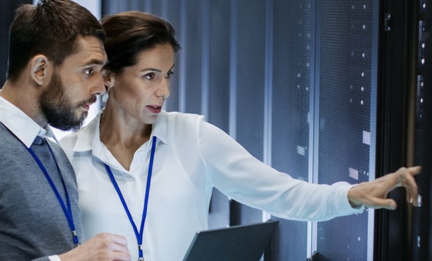 male and female professionals looking at an array of servers