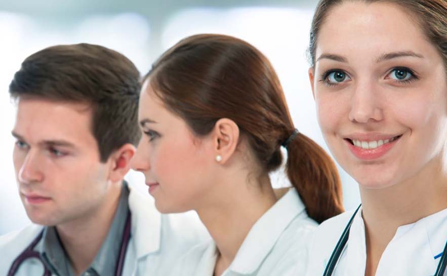 The individuals in white medical coats with stethoscopes around their necks.